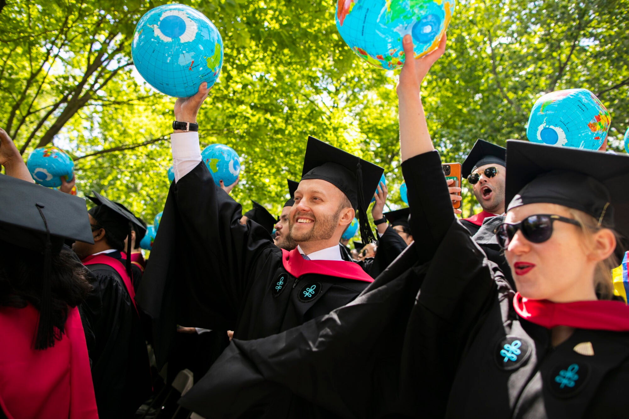 Graduates holding inflatable globes
