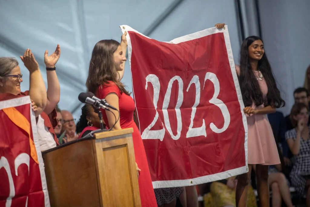 Two people holding up a banner that says "2023"