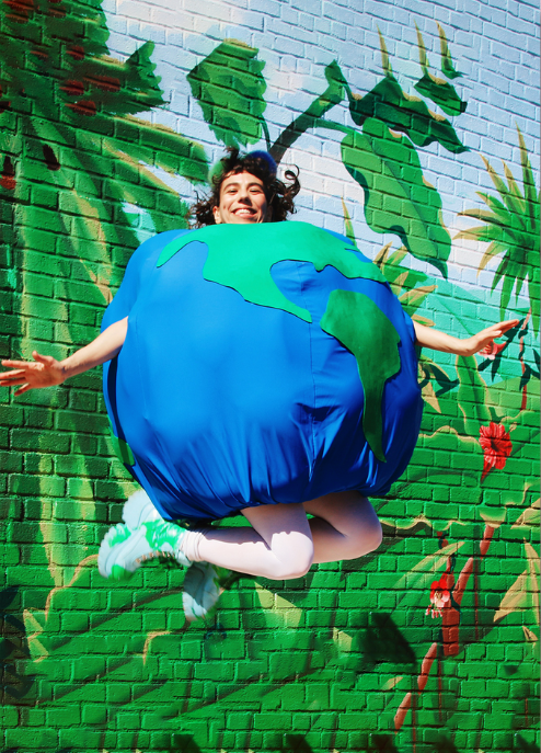 A person in an Earth costume jumping