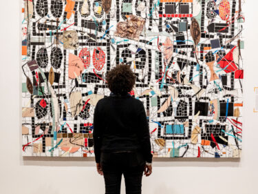 A person looks at a work of art on the wall of a museum