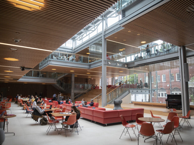 People sitting on red couches in an open, sun-filled space