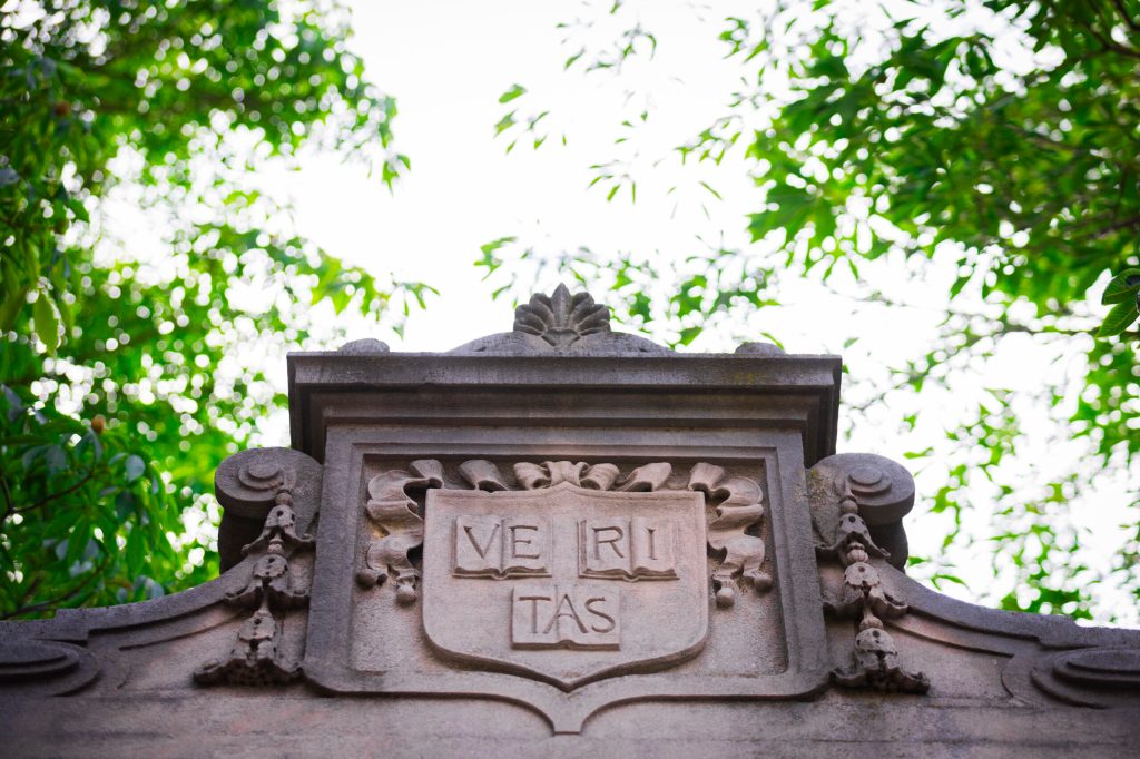 The Harvard shield at the top of a cement gate