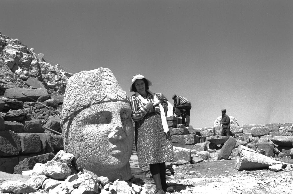 A black and white photo of a woman at an archeology site