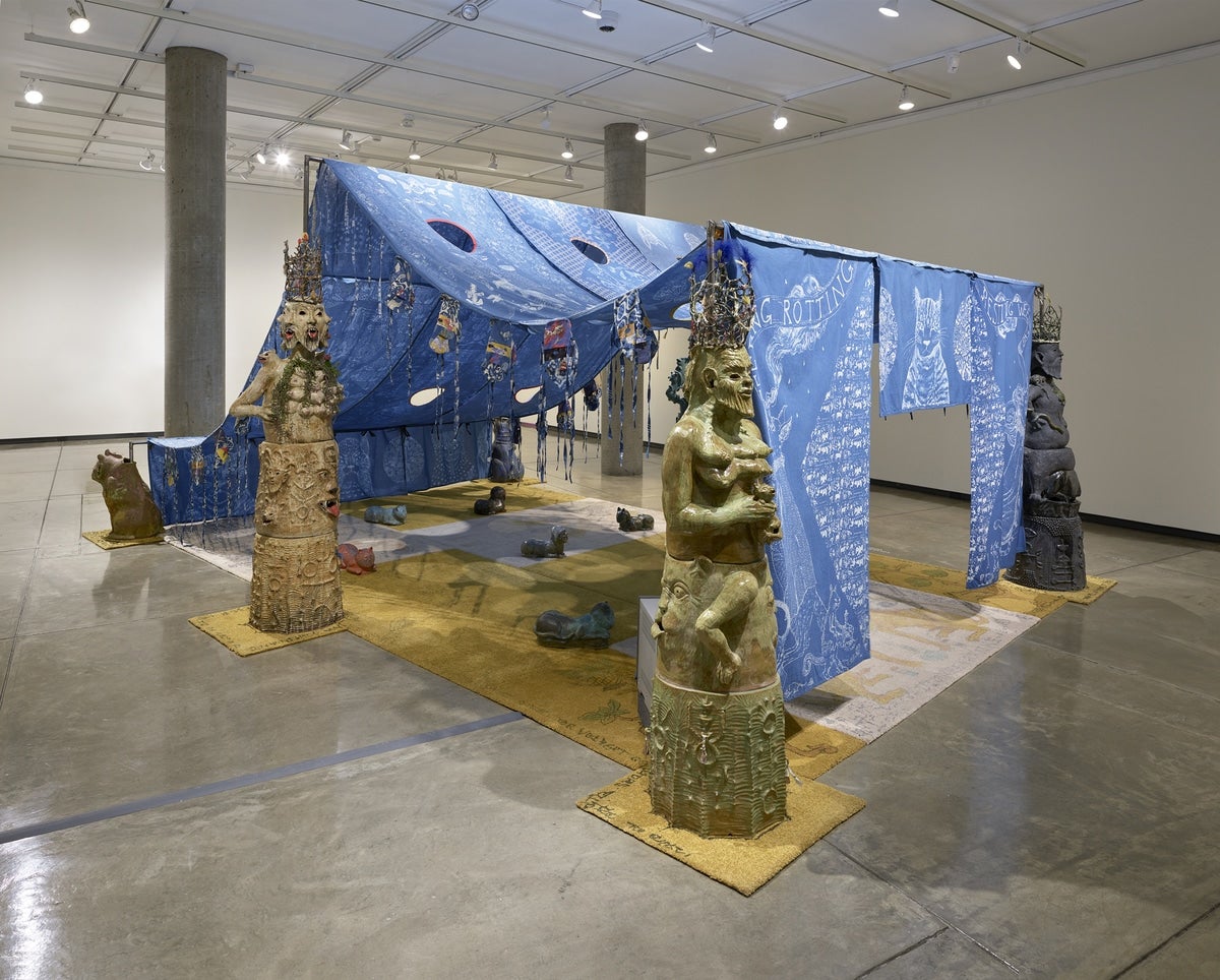 A tent made of cloth surrounded by statues