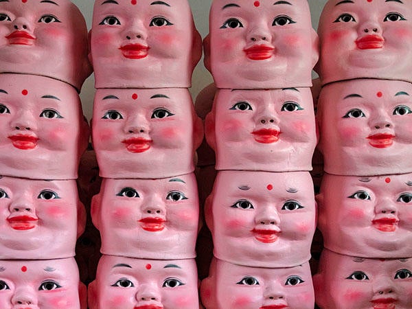 A stack of painted doll heads