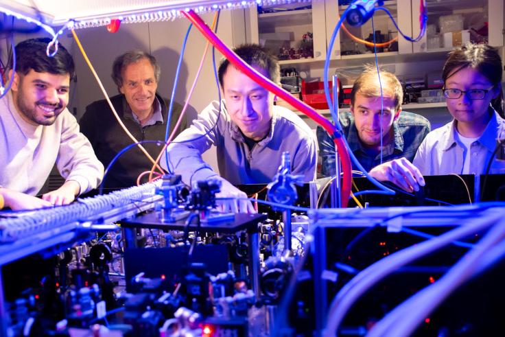 Researchers looking in at an array with wires and lasers
