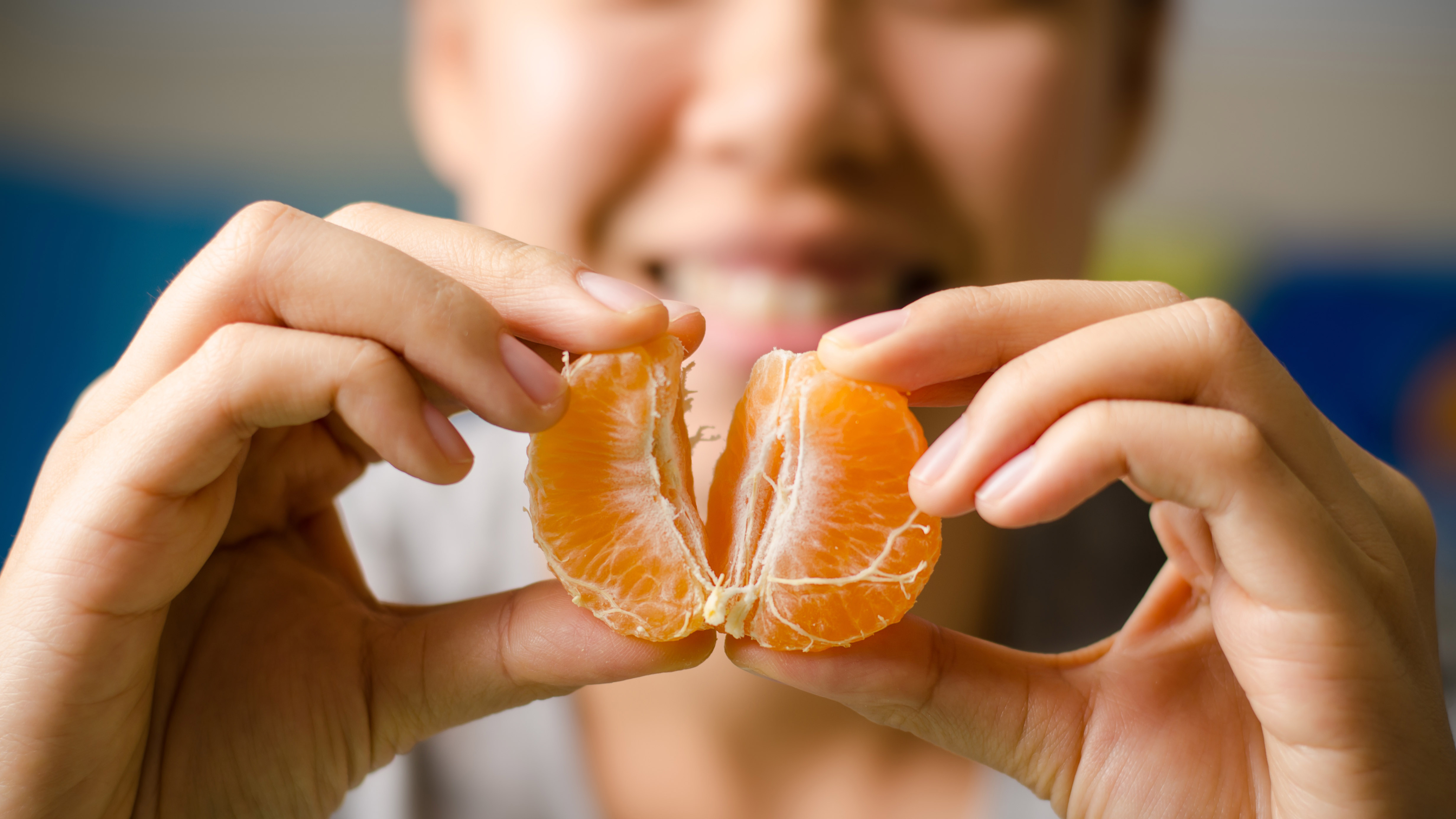 A person eating an orange