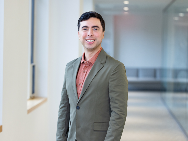 Adam Delgado poses in a gray blazer.