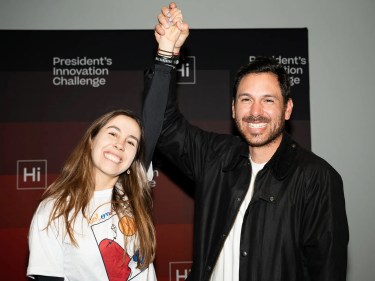 Two smiling people hold hands above their heads.